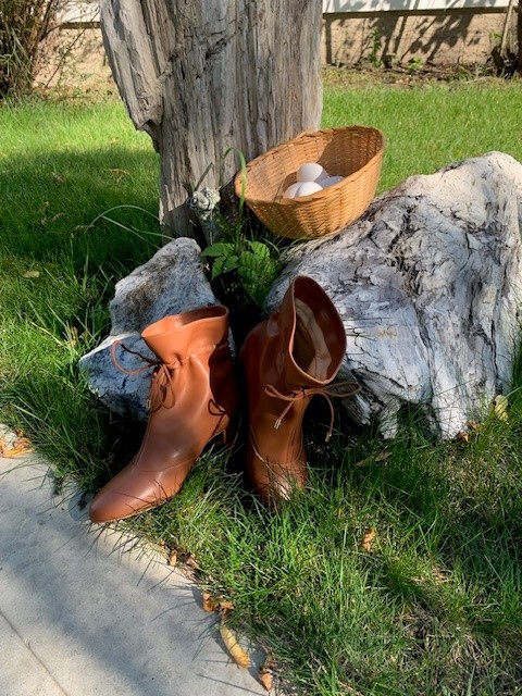A pair of boots in front of a tree.