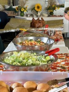 A picture of the food, including a roasted pig, at week three of AFSC's Farmer Feed - north event.