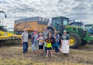 The winners of Meals in the Field, week 3 pose in front of some farm equipment.