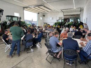 Ponoka Foodgrains harvest participants seated in a hall. They are gathered for a communal meal.