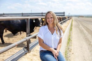 A woman sitting in front of a corral