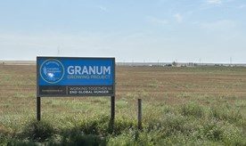 The Granum Foodgrains sign in front of the harvested field.