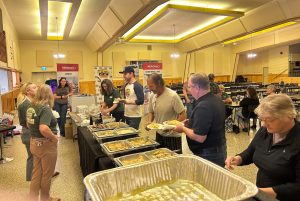 People move through a buffet line.
