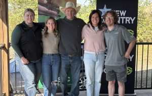 Five people with their arms around each other pose for a photo