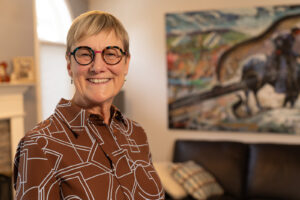 A smiling woman in front of western artwork