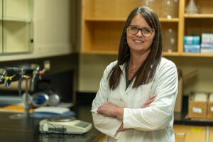 A woman stands in a laboratory.