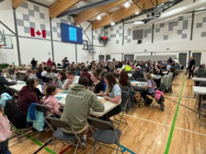 A group of people gathered in a school gym for an event.
