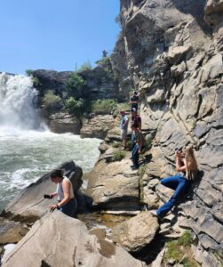 Several youth admire a waterfall