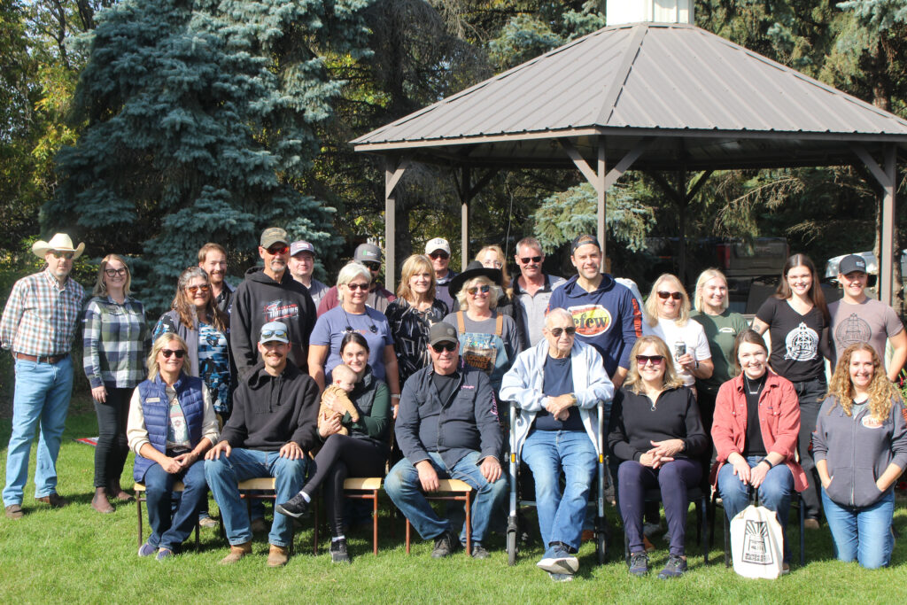 A group of people stand in front of a gazebo for a photo