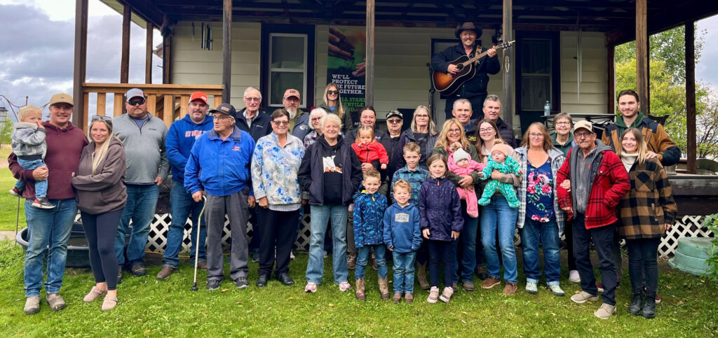 A group of people gathered in front of a house for a photo
