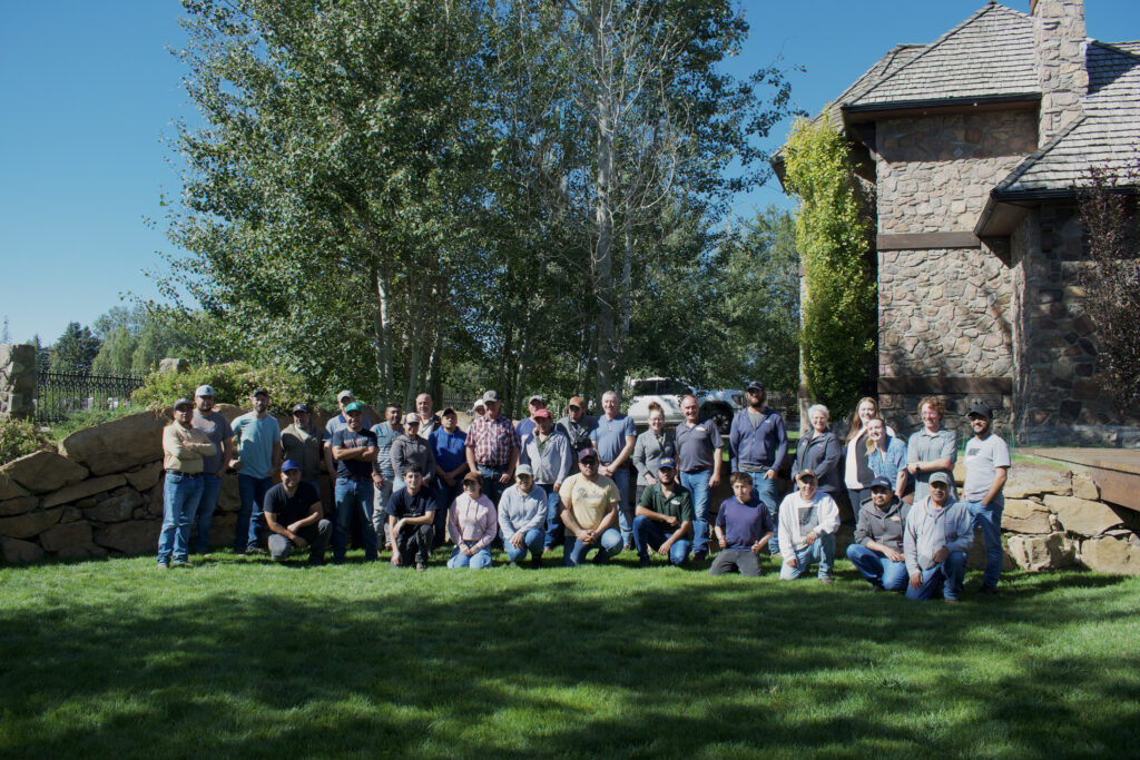A group of people pose in front of a tree for a photo